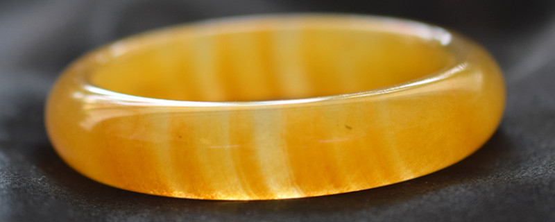 What are the effects of the gold-rimmed jade bracelet?